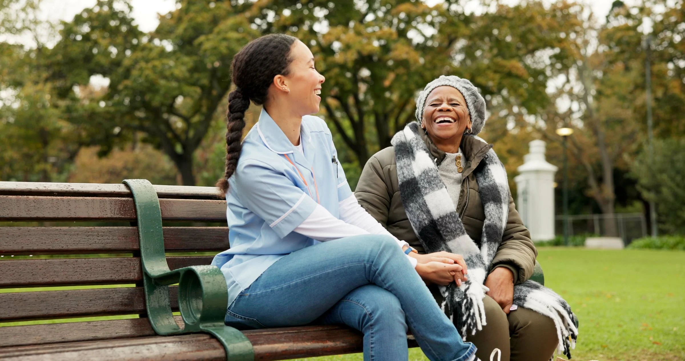 Two women talking and laughing on a park bench
